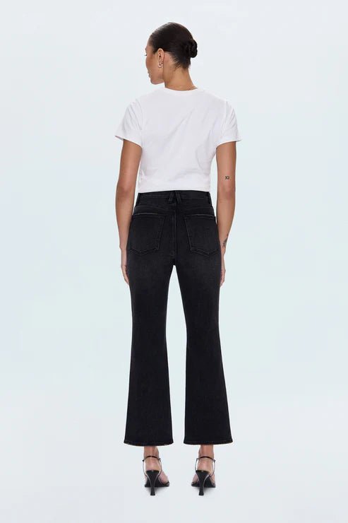 Person wearing a white t-shirt and black flared jeans on a white background