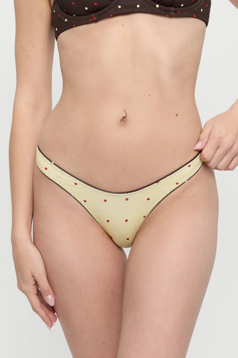 Woman wearing a beige bikini with a white background