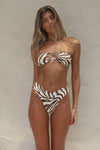 Woman wearing a zebra print bikini against a neutral background