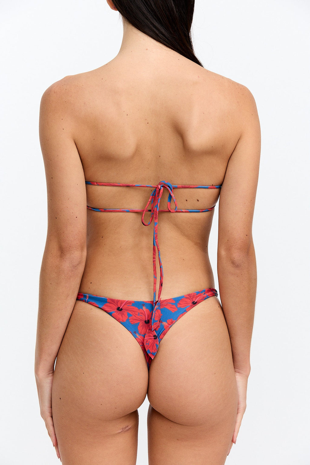Woman wearing a red and blue floral bikini on a white background