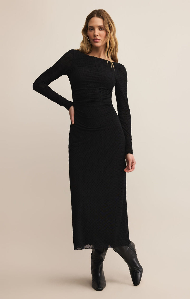 Woman wearing a black dress with long sleeves on a beige background