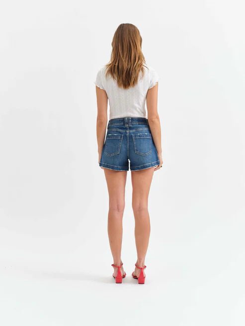 Person wearing blue denim shorts on a white background